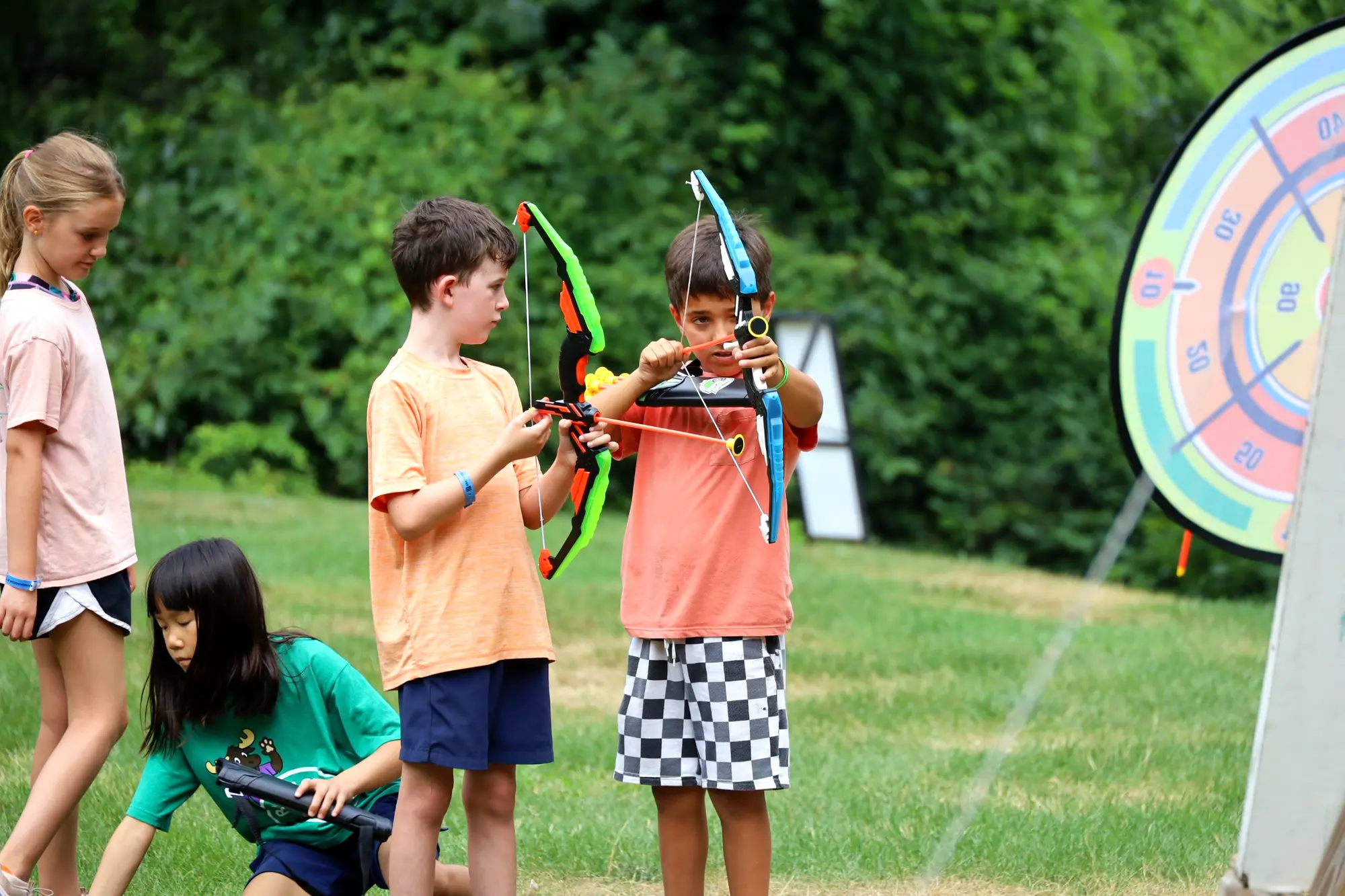 Campers practicing archery together outdoors