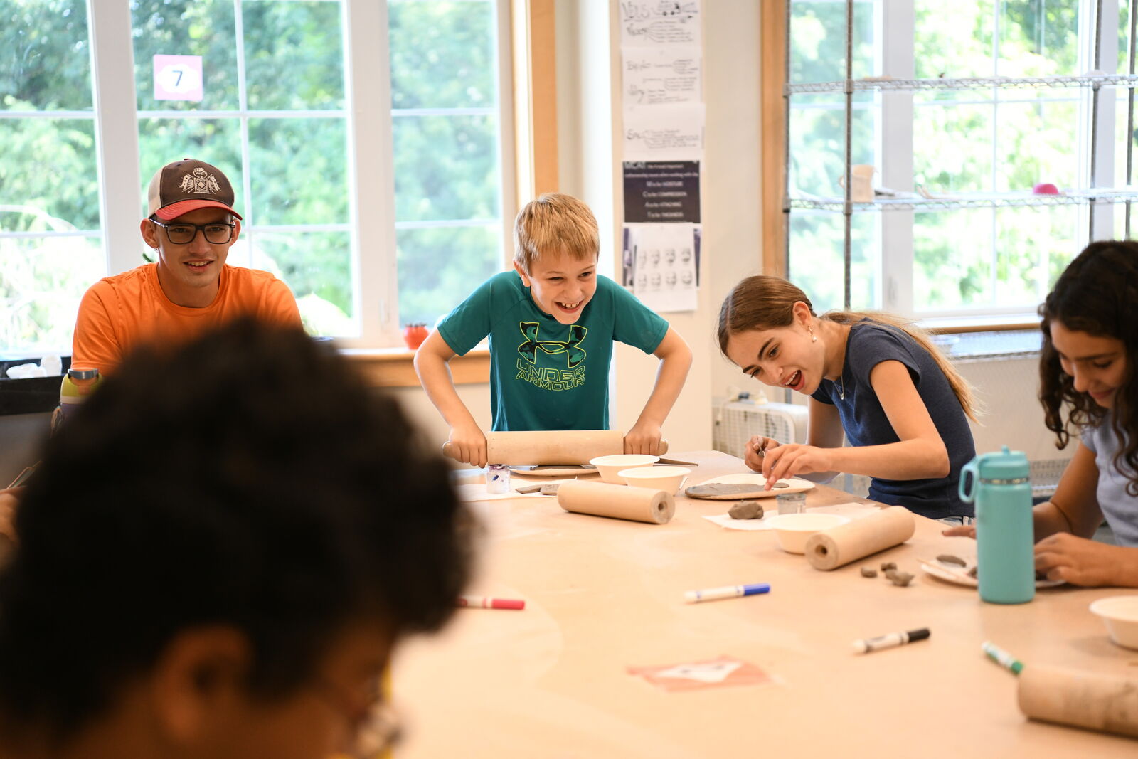 A counselor guiding campers through a tabletop activity